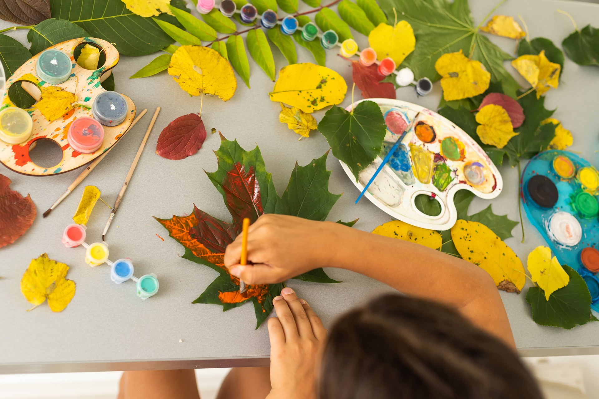 Notepad with watercolor paintings autumn leaves. View of workplace artist